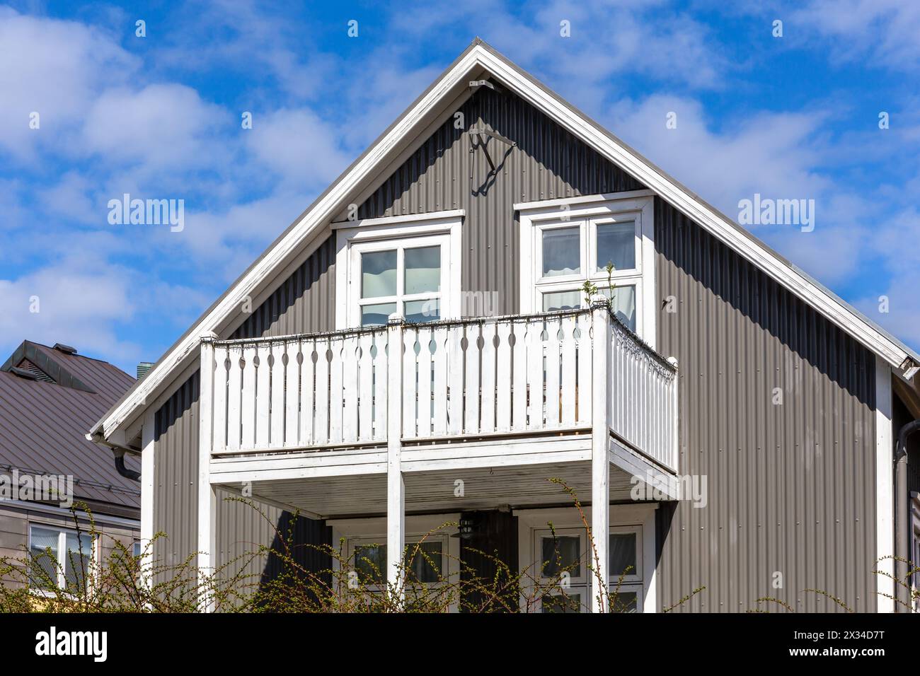 Maison résidentielle traditionnelle islandaise en fer avec toit à pignon, cadres de fenêtre blancs, revêtue de tôles ondulées à Reykjavik, Islande Banque D'Images