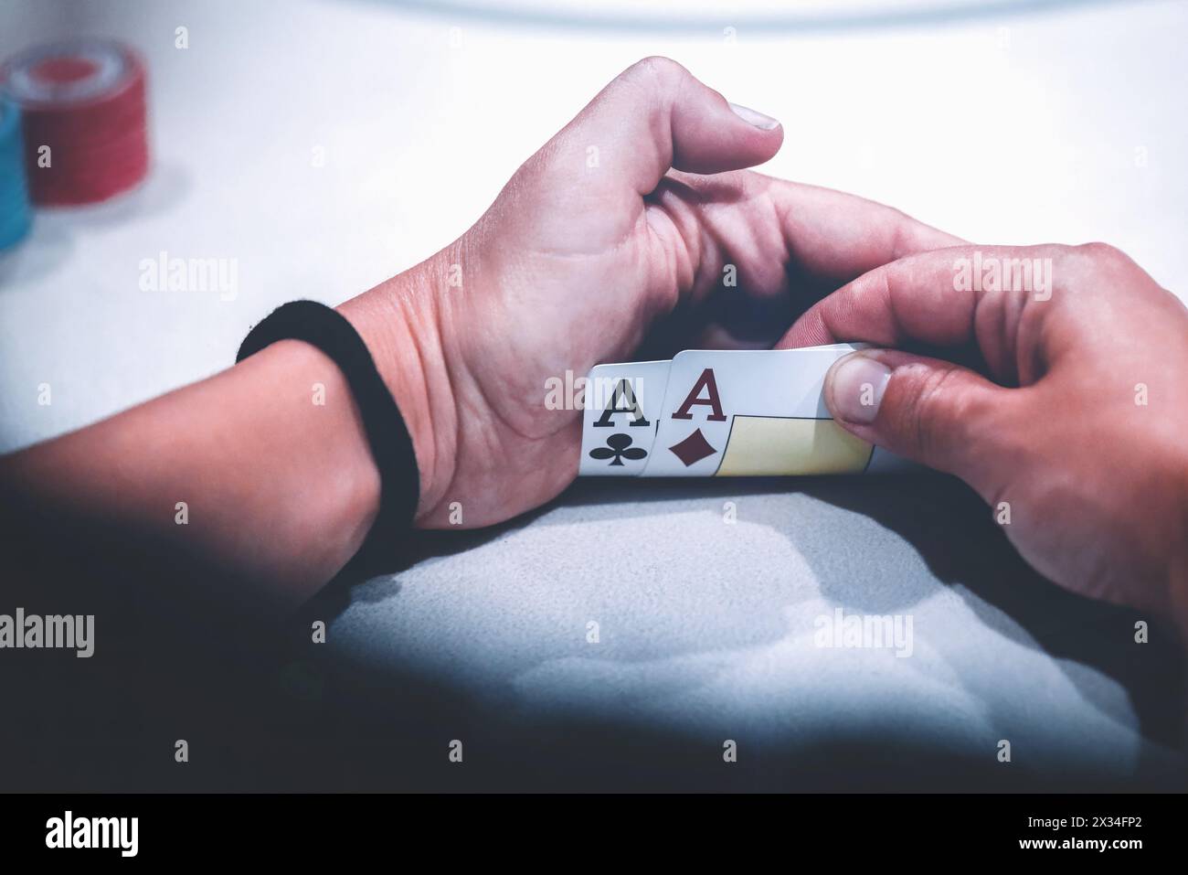 Vue rapprochée d'une main de joueur de poker tenant secrètement une paire d'as, la main de départ la plus forte dans Texas Holdem Banque D'Images