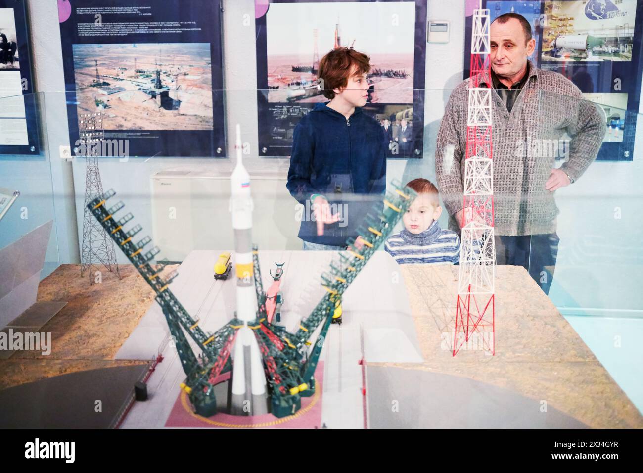 MOSCOU, RUSSIE - 7 janvier 2015 : Grand-père et deux enfants (avec autorisations du modèle) regardent le modèle du complexe de lancement du cosmodrome de Baïkonour avec le porte-avions Banque D'Images