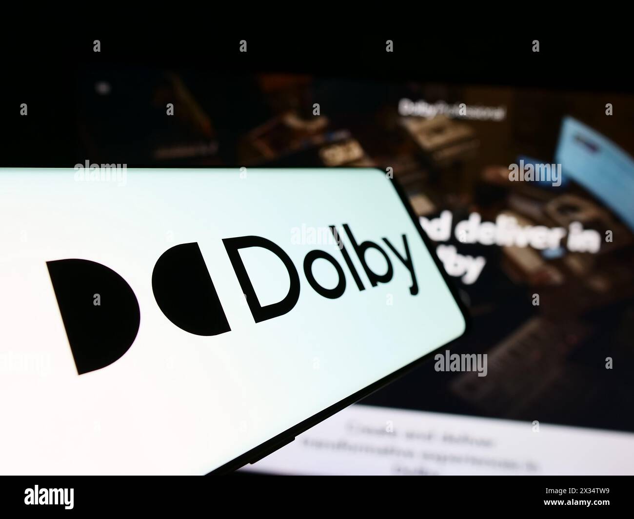 Téléphone portable avec le logo de la société de technologie audio Dolby Laboratories Inc. en face du site Web de l'entreprise. Mettez l'accent sur le centre-gauche de l'écran du téléphone. Banque D'Images
