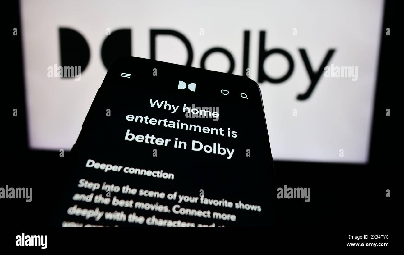 Téléphone portable avec le site Web de la société de technologie audio Dolby Laboratories Inc. devant le logo de l'entreprise. Concentrez-vous sur le coin supérieur gauche de l'écran du téléphone. Banque D'Images