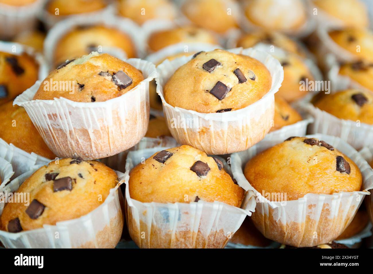 muffins aux pépites de chocolat au premier plan empilés ensemble Banque D'Images