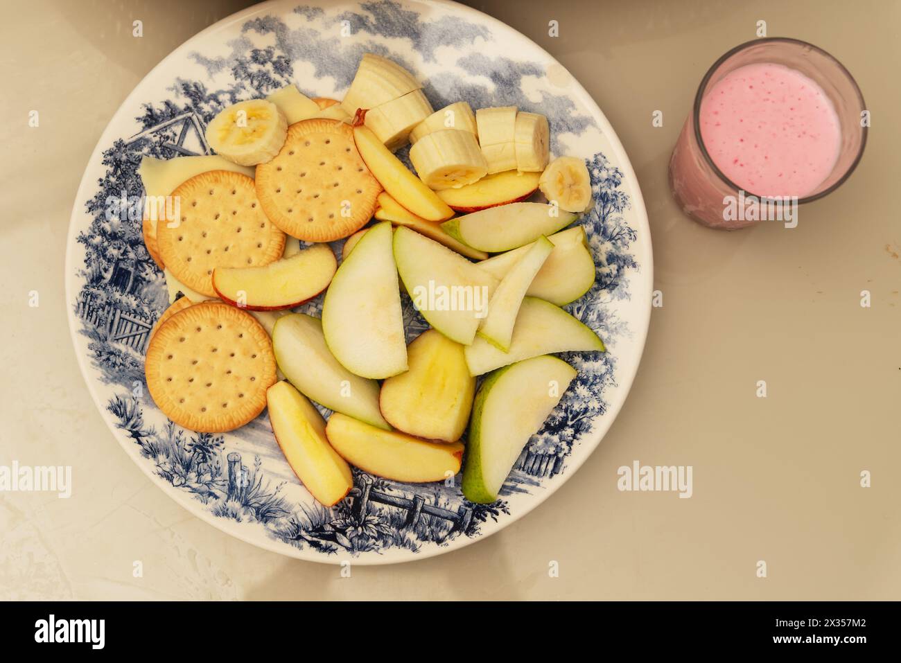 Assiette de nourriture avec banane, pomme, poire, biscuit, fromage et yaourt. Petit déjeuner sain. Régime alimentaire Banque D'Images