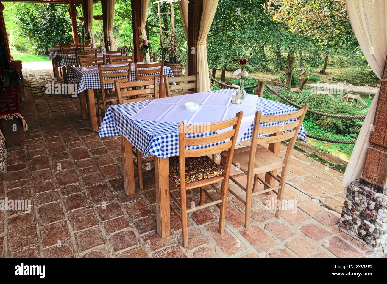 Salle de restaurant extérieure de style campagnard sur le porche du ménage ethno-écologique « skok po Skok » le long du sentier menant à la source de la rivière Gradac, Ser Banque D'Images
