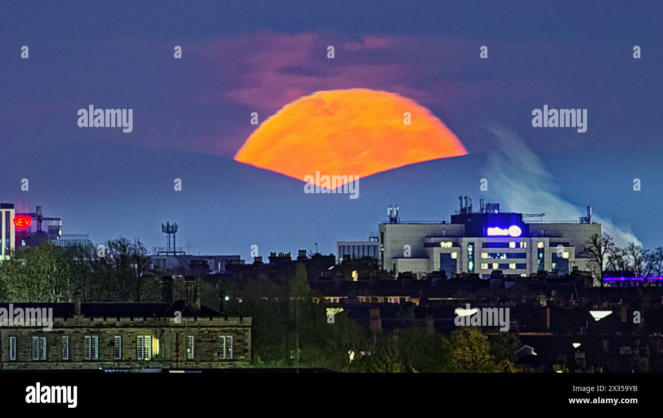 Glasgow, Écosse, Royaume-Uni. 24 avril 2024 : Météo britannique : pleine lune sur la colline de Tinto dans les frontières où les druides ont fait des sacrifices humains devant le Hilton et la fumée de la distillerie de whisky gorbals dans le centre-ville, la pleine Lune d'avril ou la pleine Lune rose est connue sous différents noms tels que la Lune d'herbe germinante, la Lune grandissante et la Lune de poisson. Crédit Gerard Ferry/Alamy Live News Banque D'Images