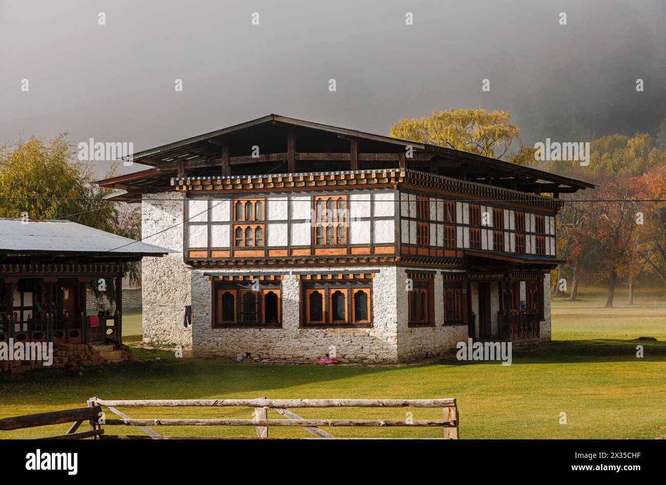 Maison de style local et bâtiments près de l'hôtel Amankora Jakar, Jakar, Bumthang, Bhoutan vu dans la brume du matin et les nuages bas Banque D'Images