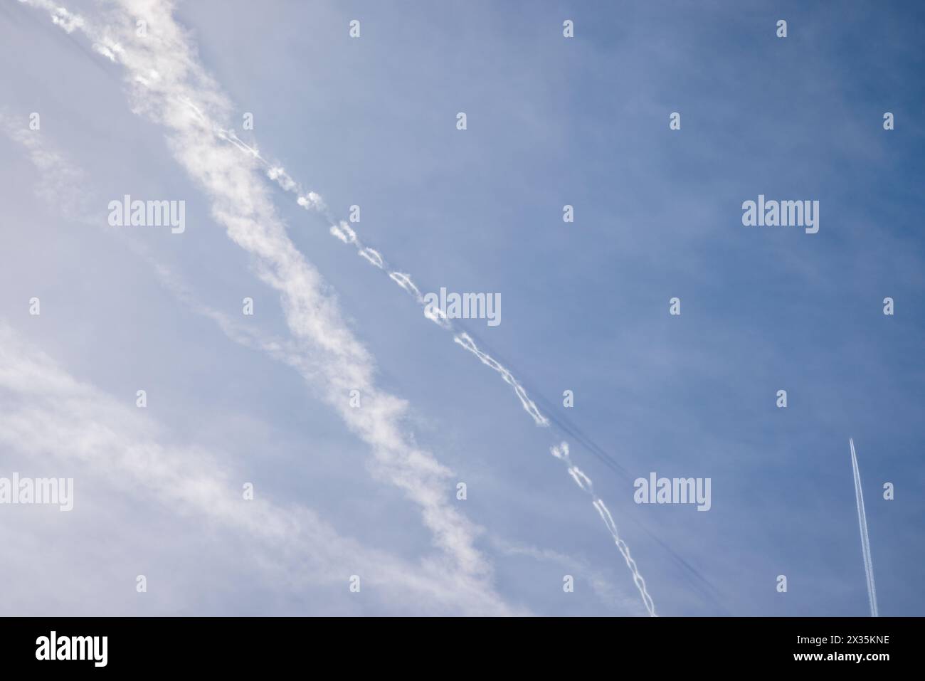 Traînées de vapeur dans le ciel bleu au-dessus de Barcelone, Espagne. Banque D'Images