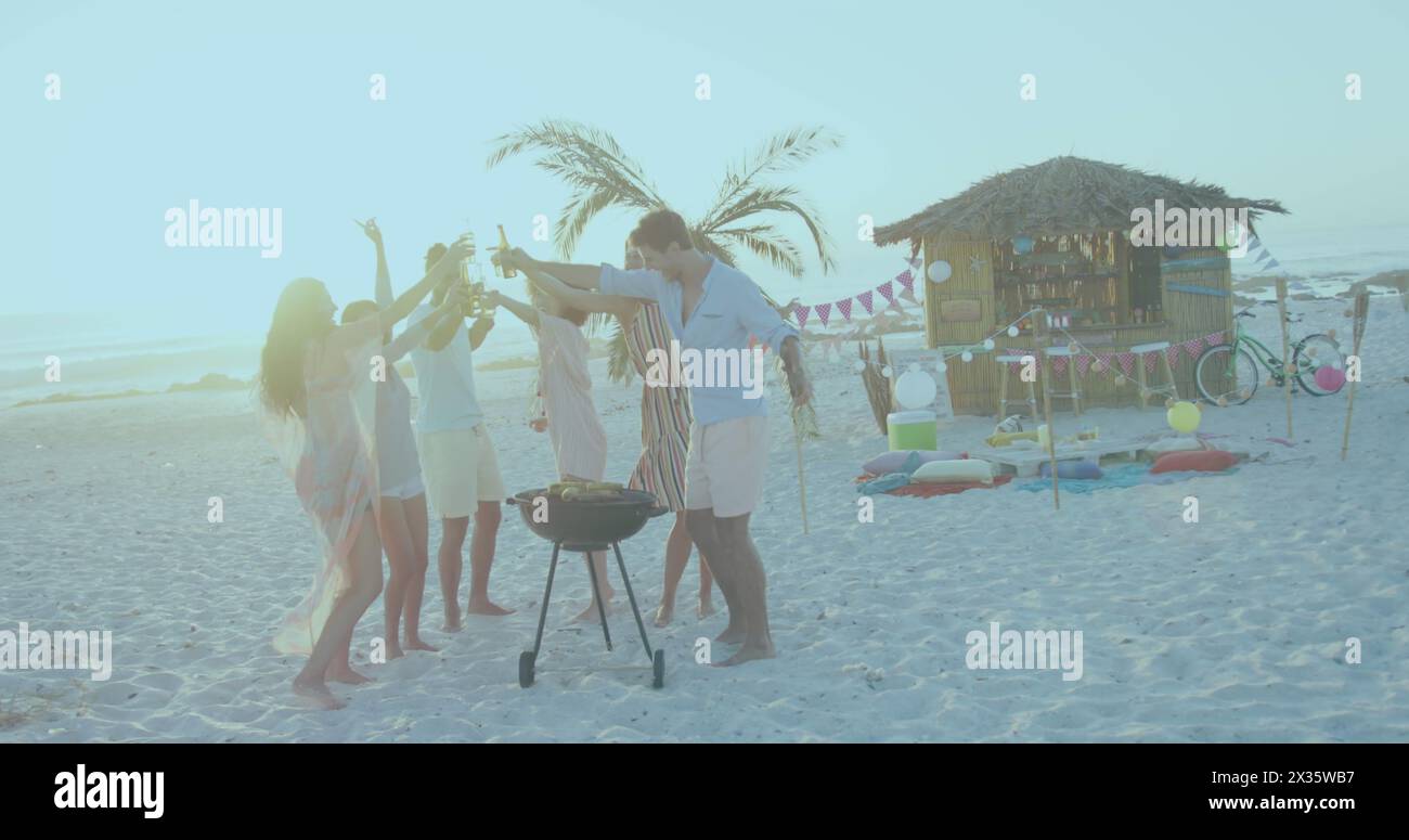 Groupe d'amis profitant d'un barbecue de plage au coucher du soleil Banque D'Images