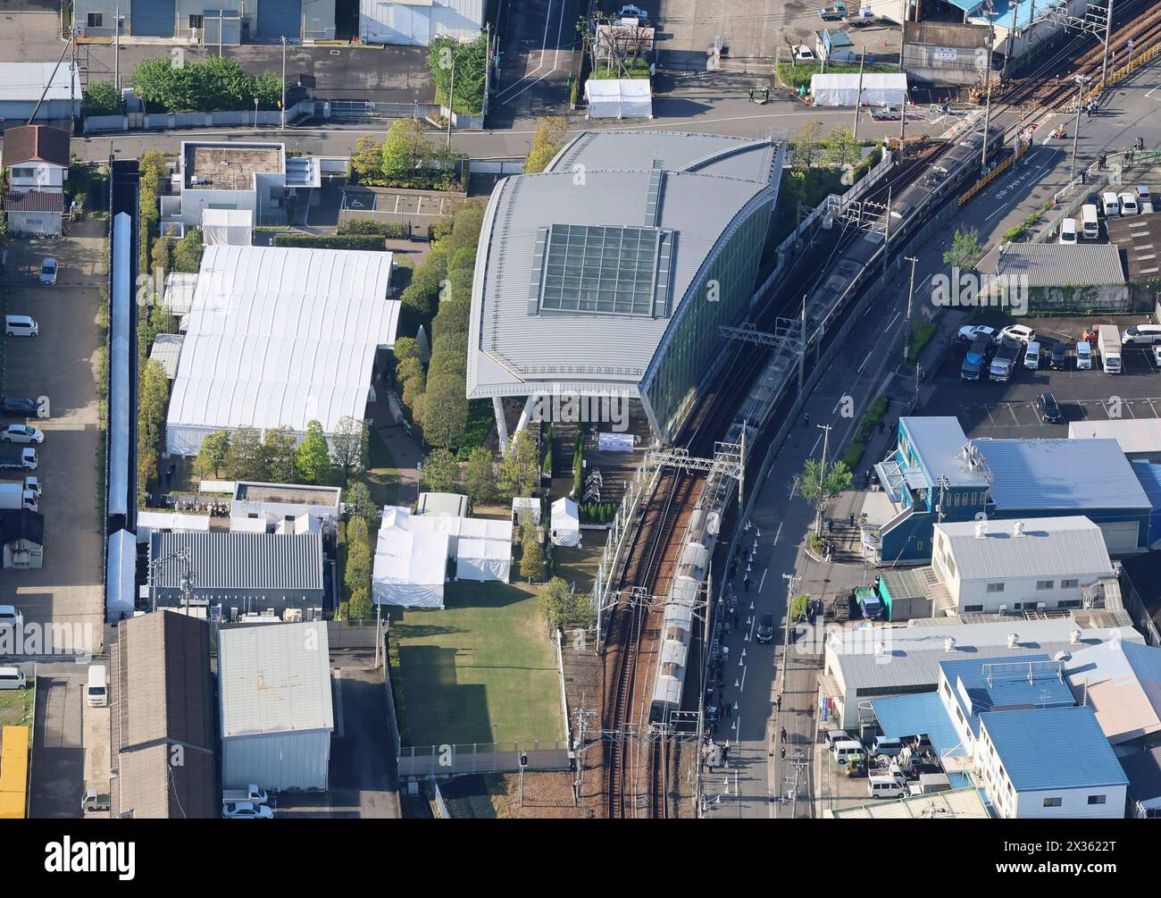 An aerial photo shows a train of the JR Fukuchiyama Line running by an accident site in Amagasaki City, Hyogo Prefecture on April 25, 2024, marking 19th anniversary of the accident. In the accident on April 25, 2005, a seven-car rapid train derailed in Amagasaki, Hyogo Prefecture, and crashed into an apartment building beside the track, claiming 107 lives, including that of the train driver, and injuring 562 other people. ( The Yomiuri Shimbun via AP Images ) Banque D'Images