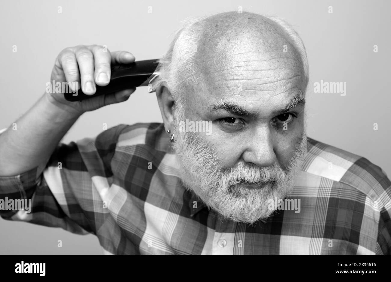 Homme avec tondeuse cheveux. Vieux chauve homme cheveux tondeuse, la calvitie mûre et la perte de cheveux concept. Banque D'Images