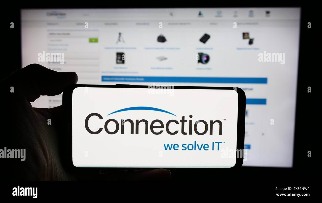 Personne tenant le téléphone portable avec le logo de la société américaine PC Connection Inc (connection.com) devant la page Web de l'entreprise. Concentrez-vous sur l'affichage du téléphone. Banque D'Images