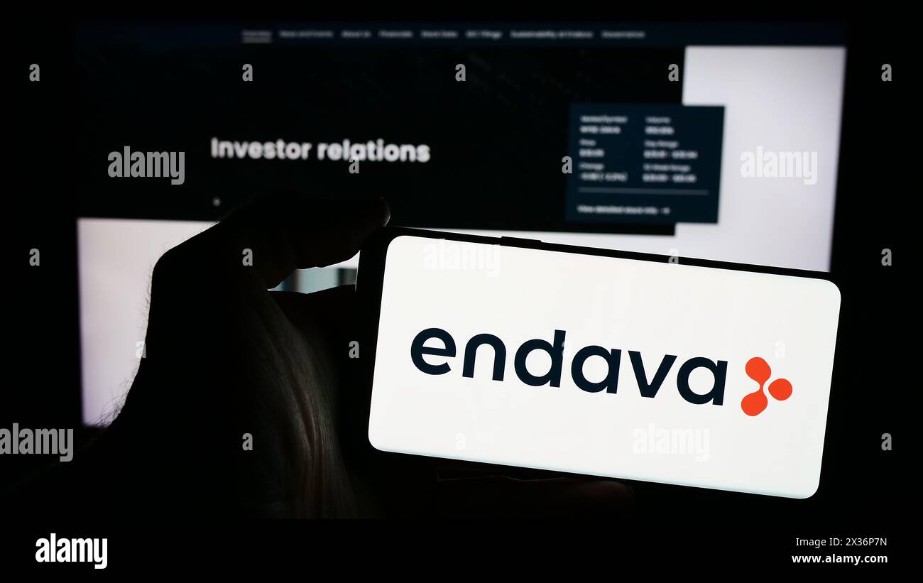 Personne tenant le téléphone portable avec le logo de la société britannique de logiciels Endava plc devant la page Web de l'entreprise. Concentrez-vous sur l'affichage du téléphone. Banque D'Images
