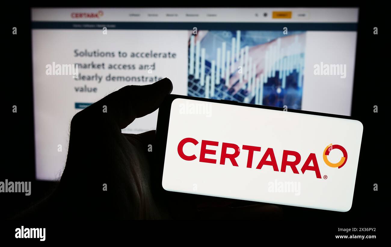Personne tenant un smartphone avec le logo de la société américaine de biosimulation Certara Inc en face du site Web. Concentrez-vous sur l'affichage du téléphone. Banque D'Images