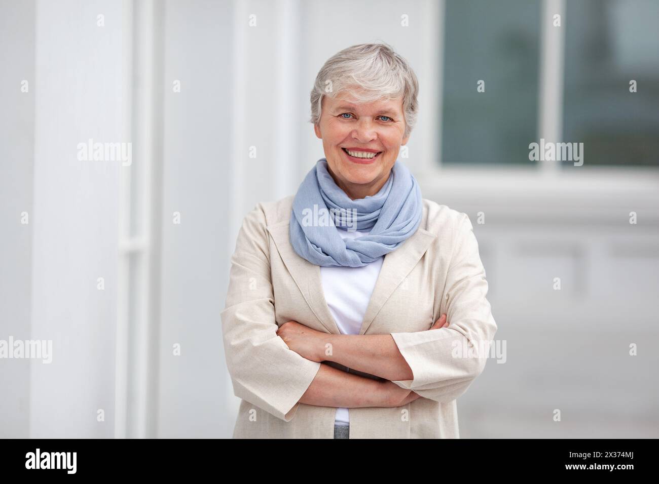 Mature heureuse belle femme d'affaires professionnelle souriante, entrepreneur modèle positif confiant heureux debout à l'extérieur sur les bras de rue croisés, féminin Banque D'Images