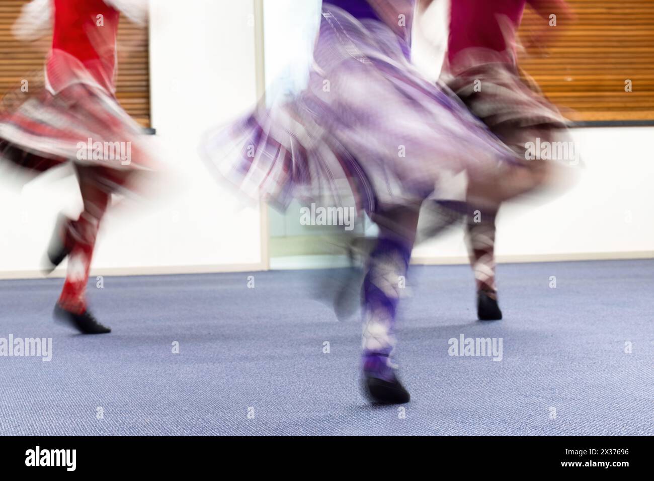 Des jeunes filles appréciant la danse des Highlands dans un club de danse. Flou de mouvement de belles jupes volantes capturées dans l'appareil photo en utilisant la vitesse d'obturation lente. Banque D'Images