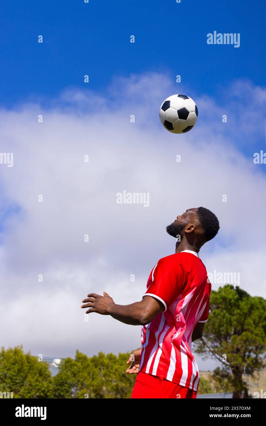 Un jeune athlète afro-américain joue au football en plein air, espace copie Banque D'Images