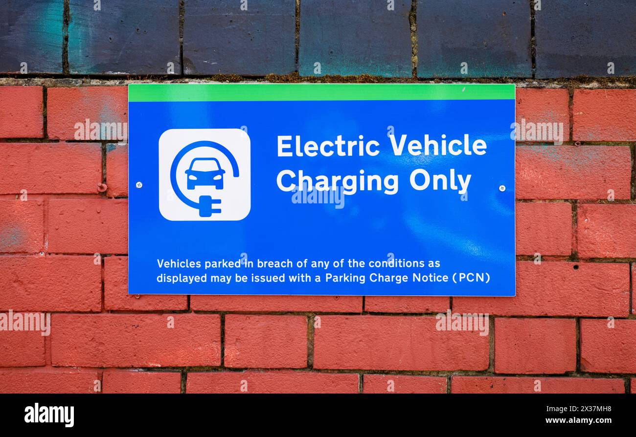 Un panneau bleu et vert indiquant une place de parking est réservé à la recharge des véhicules électriques seulement, Londres, Royaume-Uni. Banque D'Images