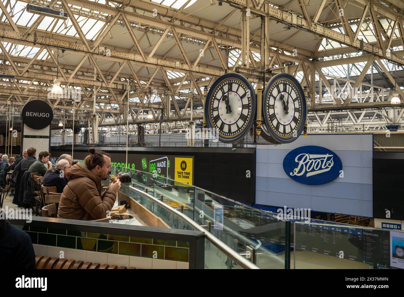 Les passagers du train mangent dans un restaurant de fièvres rapide à côté de la célèbre horloge de Waterloo Station, Lonodn, Royaume-Uni Banque D'Images