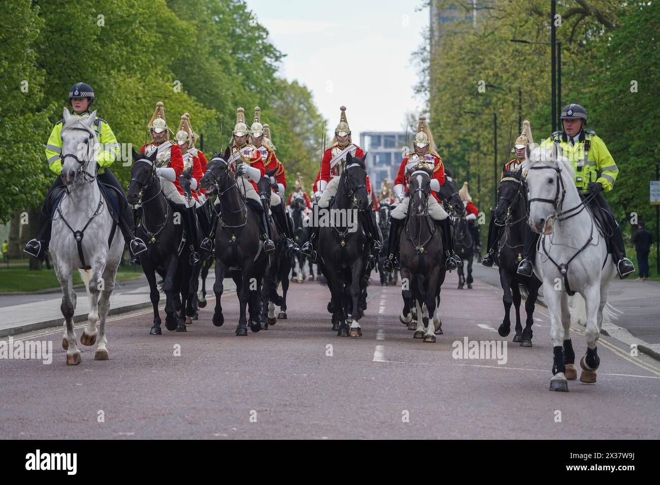 Londres, Royaume-Uni. 25 avril 2024. La police montée escorte les membres de la division montée de cavalerie domestique alors qu'ils quittent la caserne de Knightsbridge pour l'inspection du major général. mercredi, il a été signalé qu'un certain nombre de chevaux de cavalerie ont été effrayés par le bruit des constructeurs déplaçant du béton, les obligeant à boulonner et à déloger les cavaliers et à entrer en collision avec des véhicules et causer un certain nombre de blessés. Credit : amer Ghazzal/Alamy Live News Banque D'Images