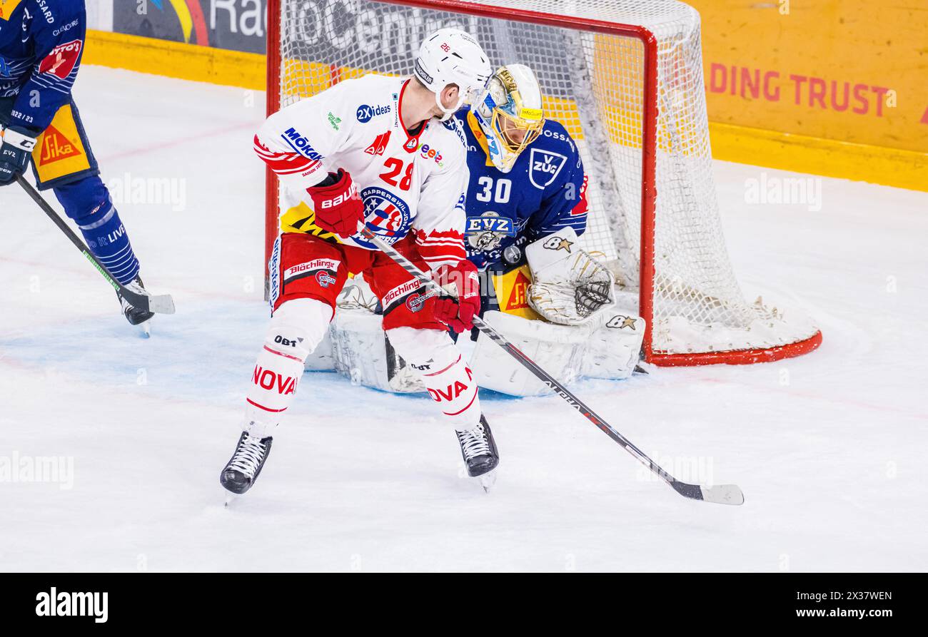 Der Rapperswiler #28 Yannick-Lennart Albrecht lenkt den Puck ab, doch Zug Torhüter#30 Leonardo Genoni hält souverän. (Zoug, Schweiz, 17.03.2023) Banque D'Images