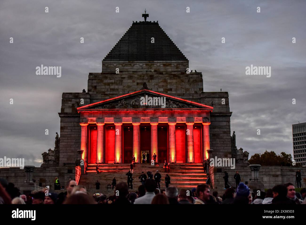 Le sanctuaire du souvenir est illuminé de rouge pendant le service de l'aube de la journée ANZAC, au mémorial du sanctuaire du souvenir de Melbourne. Le Service de l'aube est organisé dans le cadre des cérémonies de l'ANZAC Day pour honorer ceux qui sont tombés au combat. Pendant la première Guerre mondiale, l'aube est devenue un moment privilégié pour les attaques. Les soldats en position défensive étaient réveillés dans l'obscurité avant le lever du soleil et avaient leurs armes avant la première lumière. Après la première Guerre mondiale, les soldats de retour cherchaient la camaraderie qu'ils ressentaient dans ces moments calmes et paisibles avant l'aube. Rappelant les moments à l'aube avant la bataille, un service commémoratif de l'aube est devenu un impo Banque D'Images