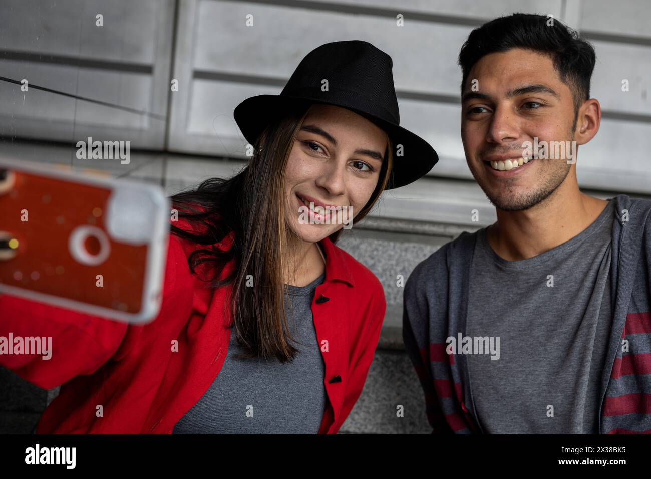 Deux jeunes frères latino-américains partagent avec joie un peu de temps ensemble en prenant un autoportrait de famille. Concept technologique. Banque D'Images