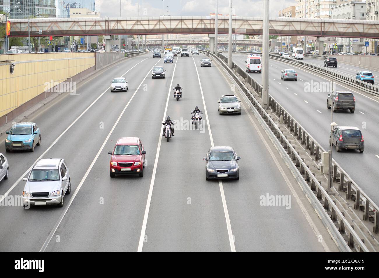 Les voitures, les vélos roulent sur la grande autoroute moderne à Moscou, en Russie au jour nuageux Banque D'Images