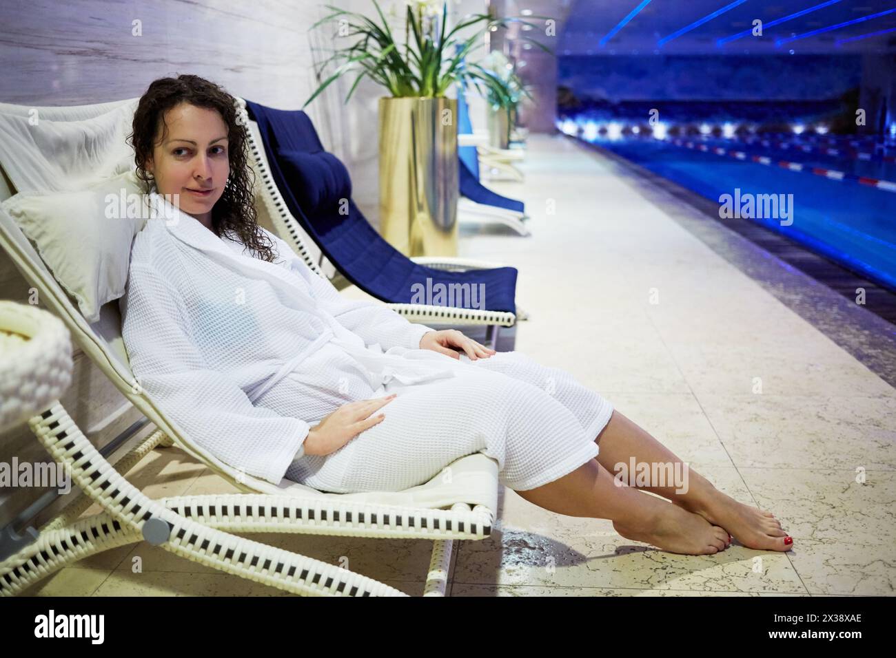 MOSCOU, RUSSIE - 14 nov 2015 : jeune femme en robe de bain est assise sur le salon au bord de la piscine dans la zone de loisirs de l'hôtel Radisson Royal Ukraine, l'un des sev Banque D'Images