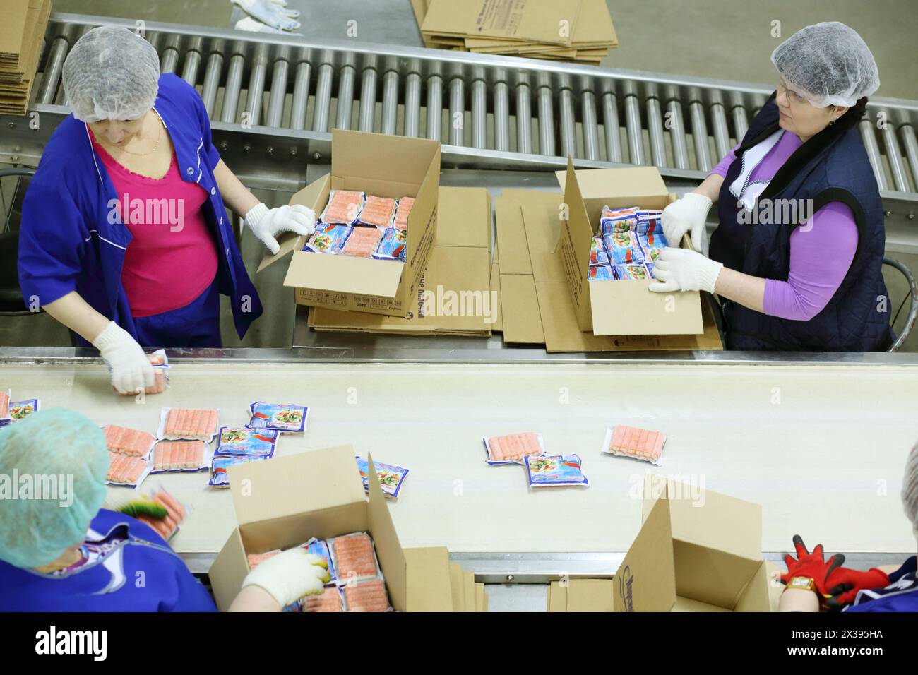 Des femmes travaillent à Conveyor dans l'usine d'emballage de poisson Banque D'Images