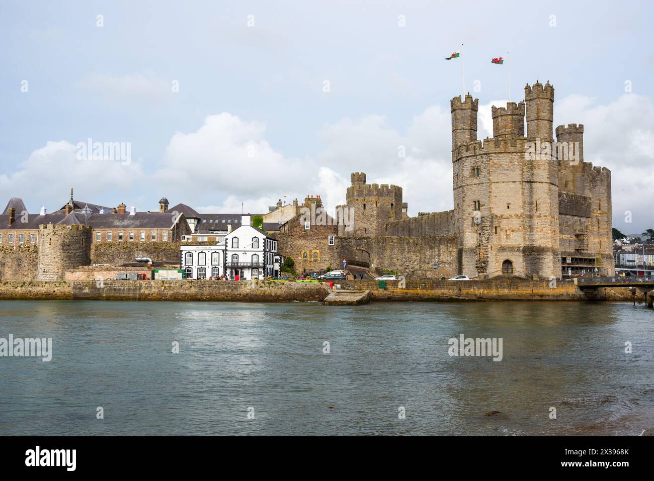 Caernarfon, pays de Galles, Royaume-Uni - 10 juillet 2023 : vue sur le front de mer et le château sous ciel nuageux Banque D'Images