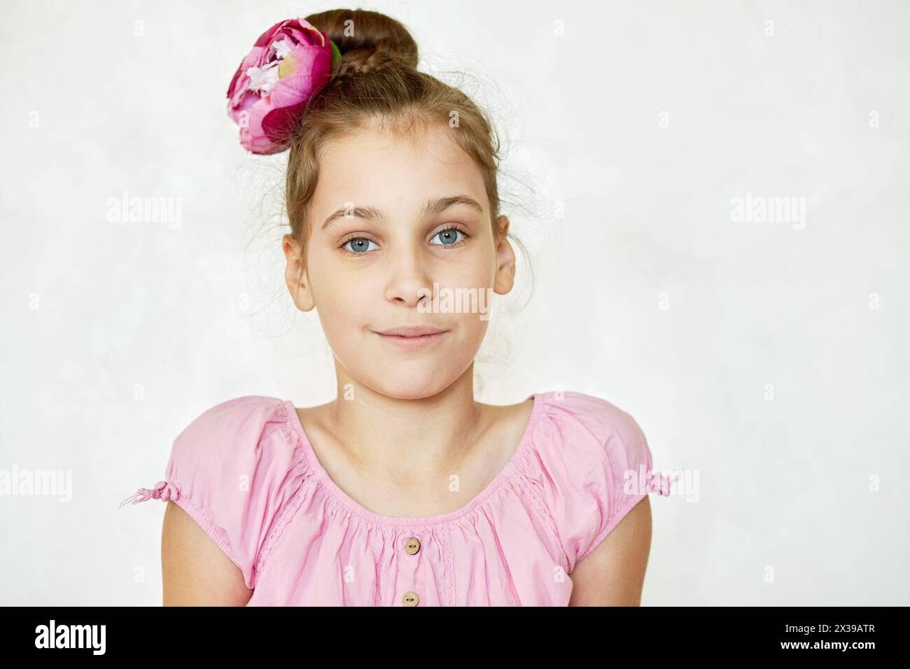 Portrait de fille en blouse rose et fleur en heardo. Banque D'Images