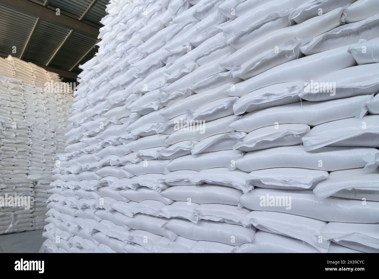 Beaucoup de nouveaux sacs blancs en plastique avec des marchandises sont dans le grand entrepôt Banque D'Images