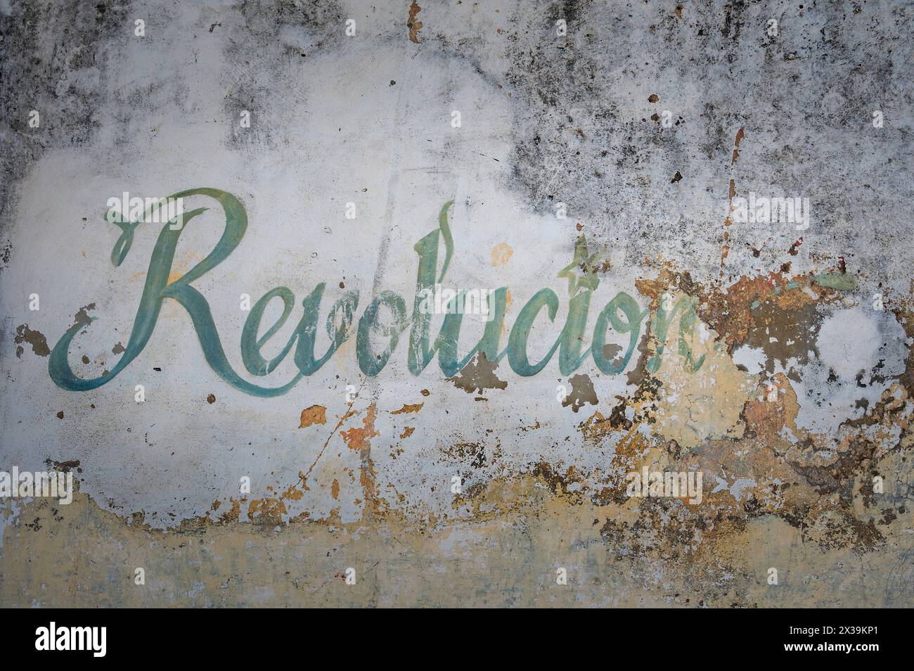 Art de rue fané sous la forme d'écriture artistique disant Revolucion (Révolution) sur un mur dans les ruelles de Cienfuegos, Cuba Banque D'Images