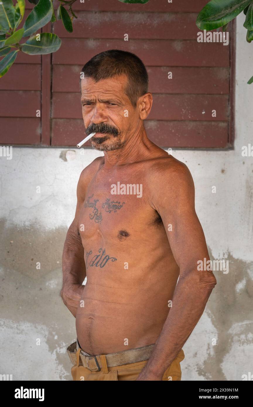 La vue régulière d'hommes tatoués se tenait autour topless devant leurs maisons dans les ruelles de Cienfuegos, Cuba Banque D'Images