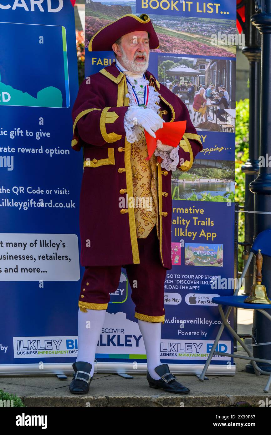 Crier de ville masculine (uniforme coloré de crieur, voix forte) proclamant, faisant la proclamation publique et annonce - Ilkley, West Yorkshire, Angleterre, Royaume-Uni. Banque D'Images