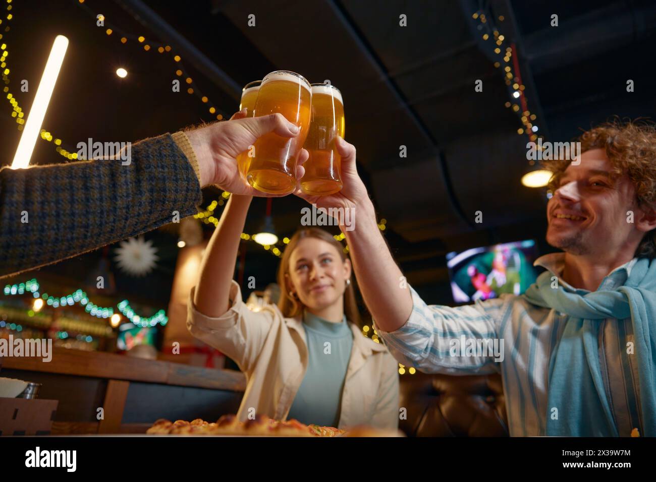 Amis buvant de la bière célébrant la fin de la semaine de travail se reposant dans un pub Banque D'Images