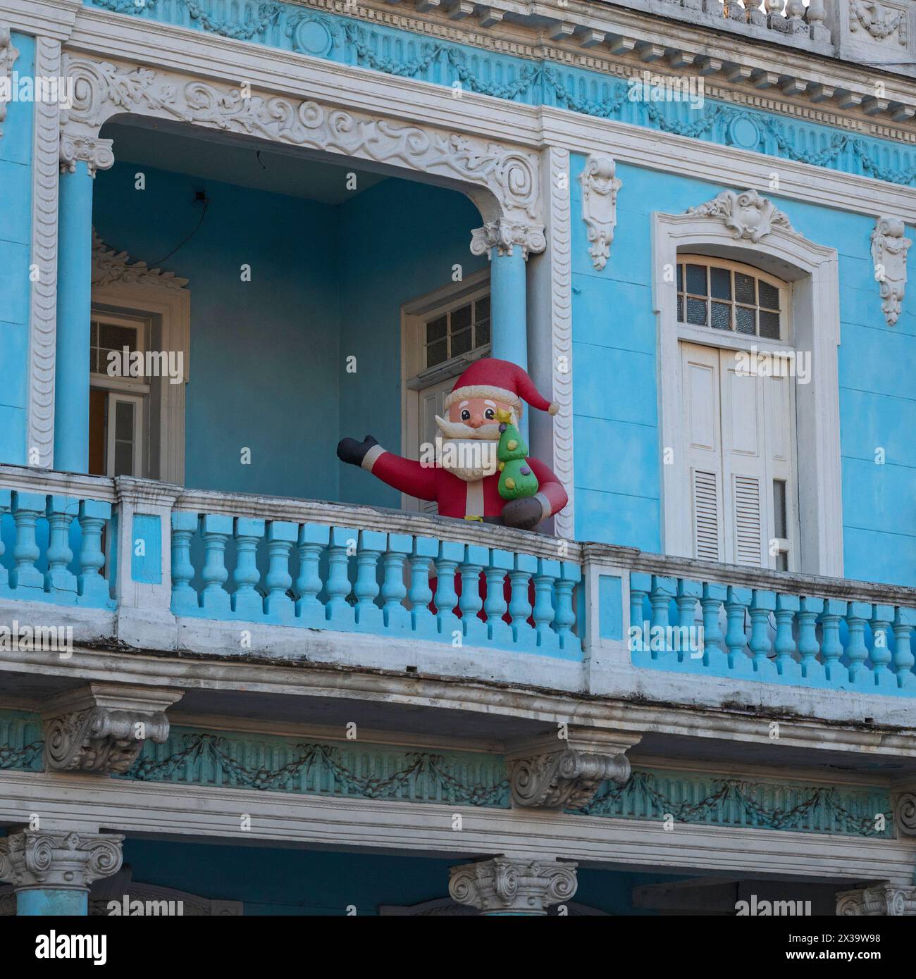 Père Noël faisant une apparition sur un balcon donnant sur Paseo el Prado dans le centre de Cienfuegos, Cuba Banque D'Images