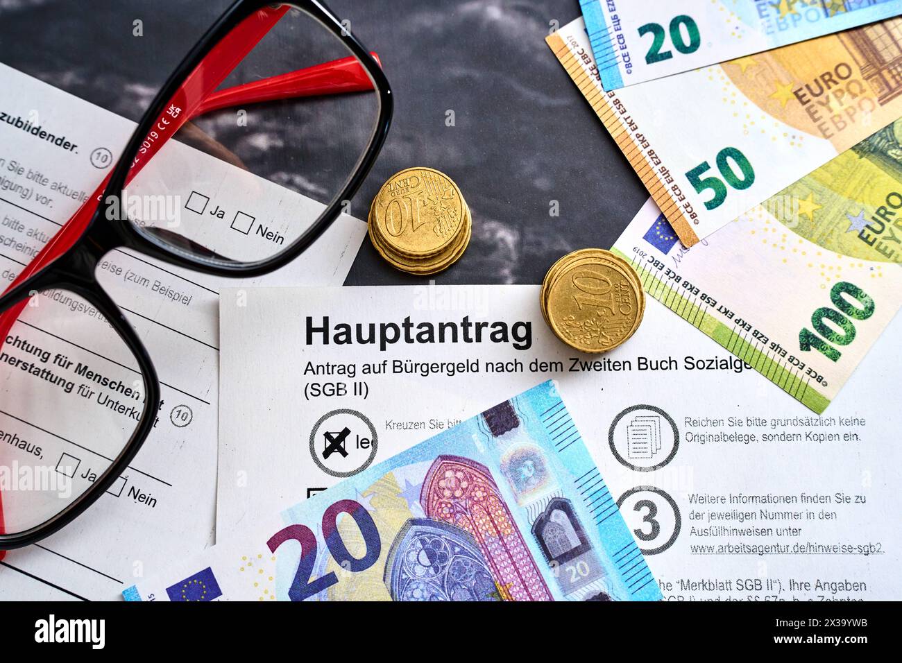 Augsbourg, Bavière, Allemagne - 25 avril 2024 : demande d allocation citoyenne, application principale pour les billets et les pièces en euros. Concept d'assistance sociale *** Antrag auf Bürgergeld, Hauptantrag mit Euro Geldscheinen und Münzen. Sozialhilfe Konzept Banque D'Images