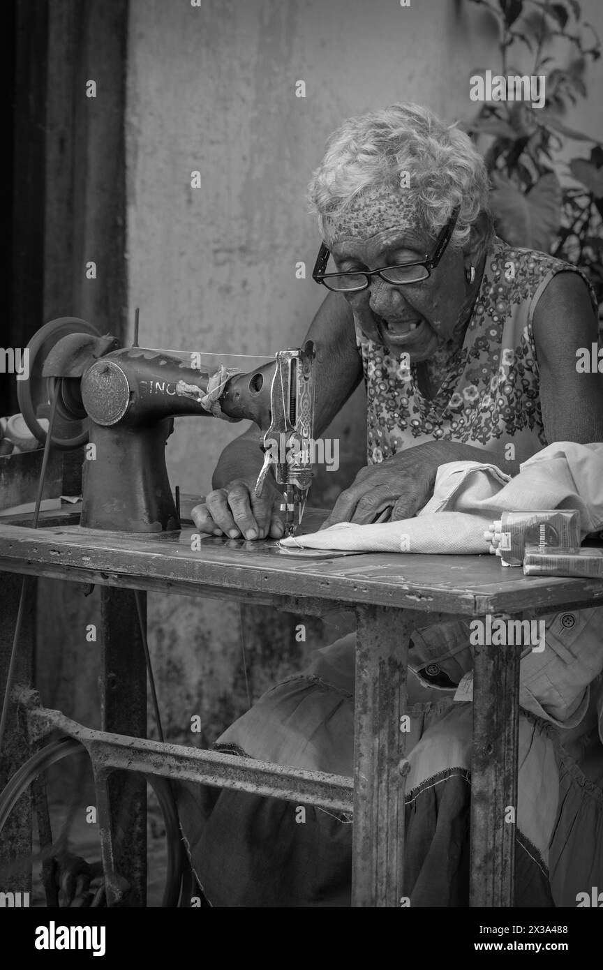 Une vieille dame travaillant avec sa machine à coudre au coin de la rue dans la vieille ville, la Havane, Cuba. Banque D'Images