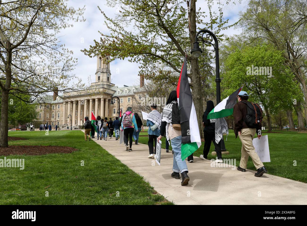 State College, États-Unis. 25 avril 2024. Les manifestants pro-palestiniens portent des drapeaux palestiniens alors qu'ils marchent vers Old main sur le campus de l'Université Penn State à State College, en Pennsylvanie, le 25 avril 2024. Penn State Students for Justice in Palestine, avec d'autres organisations, ont tenu une journée à l'Université populaire pour Gaza qui comprenait des cours, des travaux de craie sur les trottoirs et un rassemblement à Old main. (Photo de Paul Weaver/Sipa USA) crédit : Sipa USA/Alamy Live News Banque D'Images
