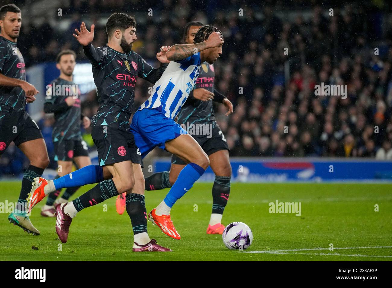 Brighton's Joao Pedro, right, duels for the ball with Manchester City's Josko Gvardiol during the English Premier League soccer match between Brighton and Manchester City at the Falmer Stadium in Brighton, England, Thursday, April 25, 2024. (AP Photo/Kin Cheung) Banque D'Images