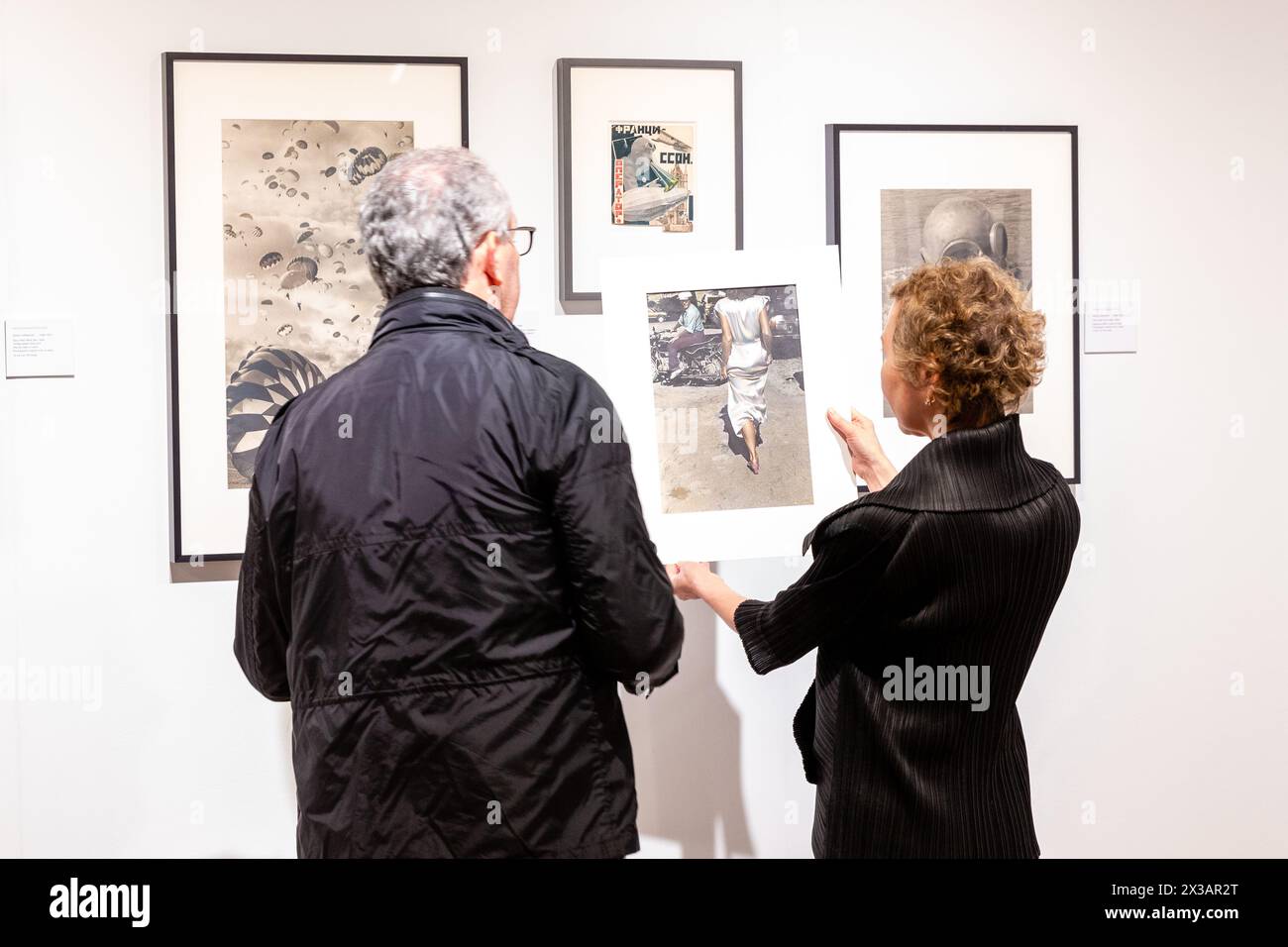 New York, NY, États-Unis. 25 avril 2024. L'exposition de photographies historiques, modernes et contemporaines de l'Association of International Photography Art Dealers (AIPAD) a ouvert ses portes à l'Armory Park Avenue. Un galeriste dans le kiosque de la Galerie Vasari/Nailya Alexander montre une impression à un visiteur. Crédit : Ed Lefkowicz/Alamy Live News Banque D'Images