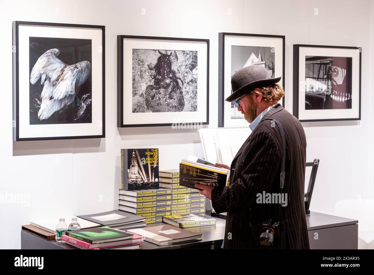 New York, NY, États-Unis. 25 avril 2024. L'exposition de photographies historiques, modernes et contemporaines de l'Association of International Photography Art Dealers (AIPAD) a ouvert ses portes à l'Armory Park Avenue. Un visiteur regarde le livre de Peter Fetterman "le pouvoir de la photographie" sur le stand de Fetterman. Crédit : Ed Lefkowicz/Alamy Live News Banque D'Images