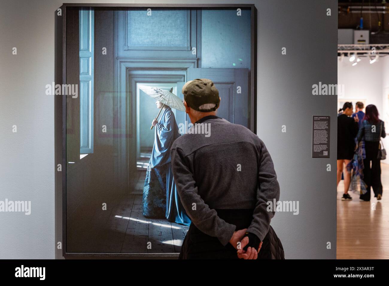 New York, NY, États-Unis. 25 avril 2024. L'exposition de photographies historiques, modernes et contemporaines de l'Association of International Photography Art Dealers (AIPAD) a ouvert ses portes à l'Armory Park Avenue. Un visiteur semble regarder dans la chambre d'une femme alors qu'il regarde une photographie de la photographe néerlandaise Ilona Langbroek dans le stand de Bild Halle. Crédit : Ed Lefkowicz/Alamy Live News Banque D'Images