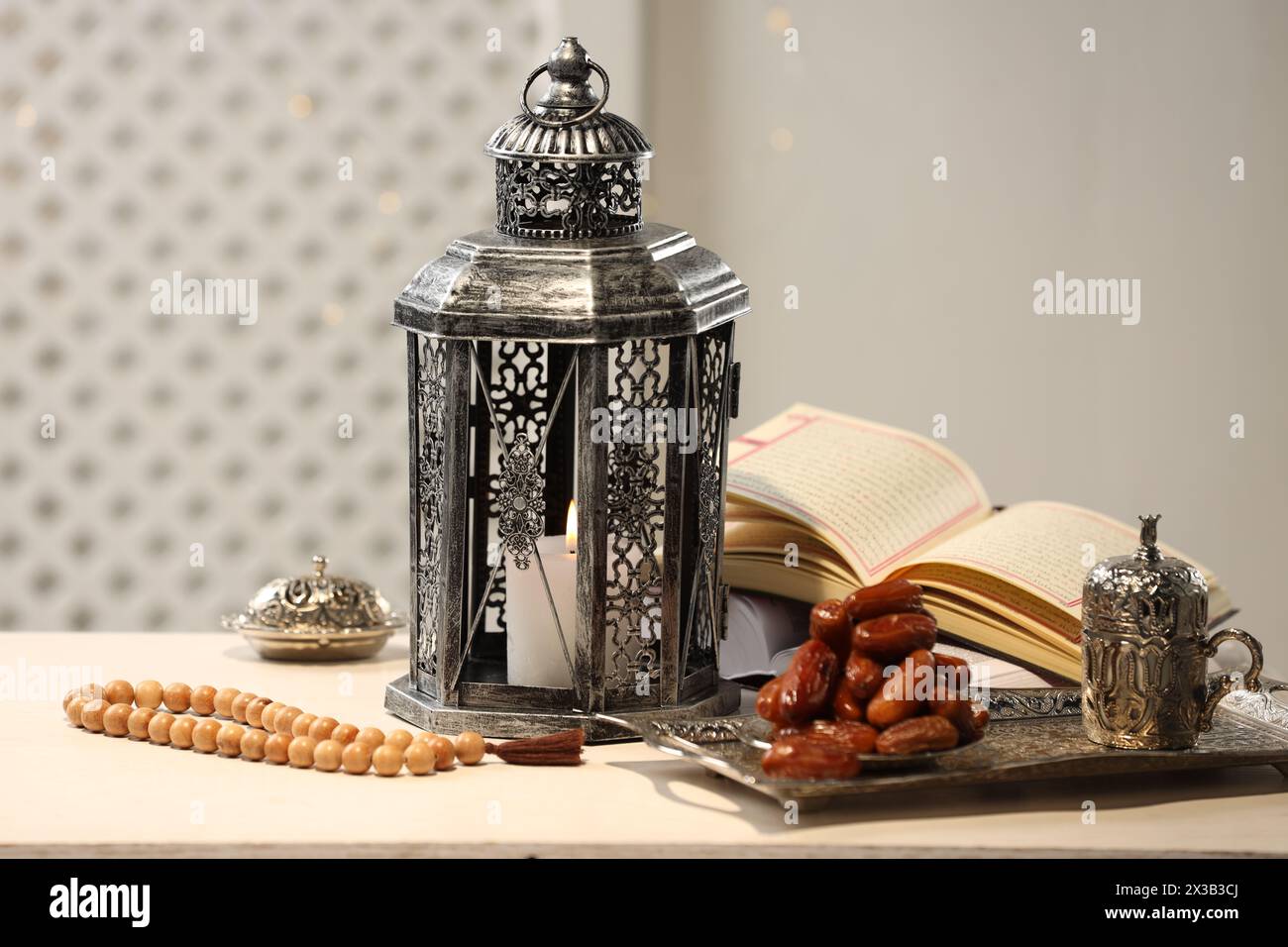 Lanterne arabe, Coran, misbaha et dates sur table blanche Banque D'Images