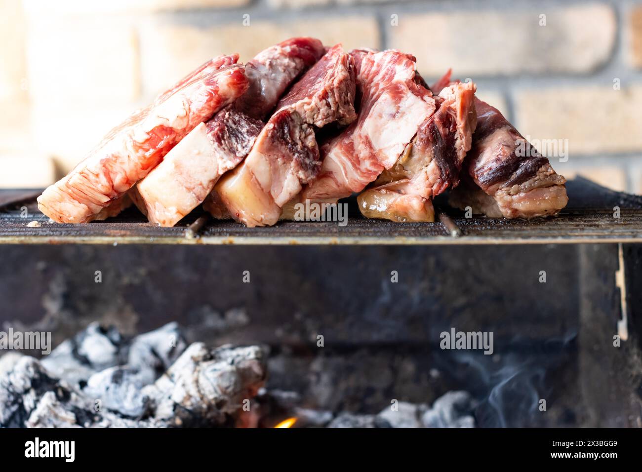 Vue de face de plusieurs morceaux de viande crue côte à côte sur un gril chaud à la journée à l'extérieur Banque D'Images