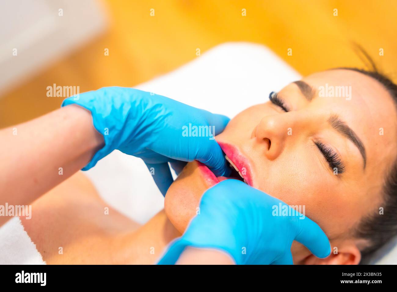 Patient recevant un massage de la mâchoire pour traiter les tensions et le dysfonctionnement de l'articulation temporo-mandibulaire Banque D'Images