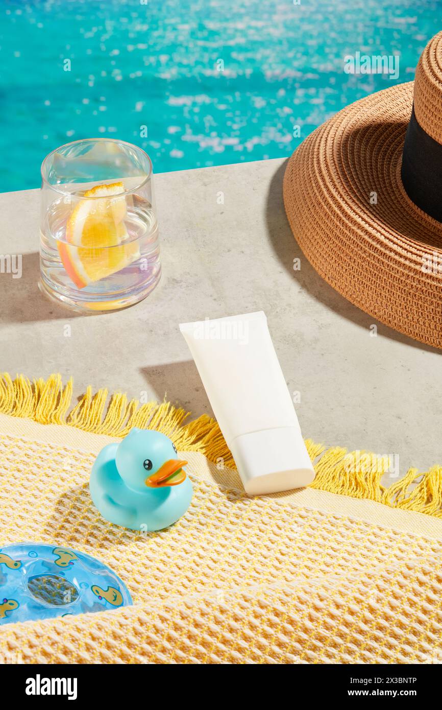Tube de crème solaire sans étiquette décoré avec un canard vous, bouée de natation, chapeau de plage, et une tasse d'eau avec une tranche d'orange à l'intérieur. Cosmétiques, produits pour Banque D'Images