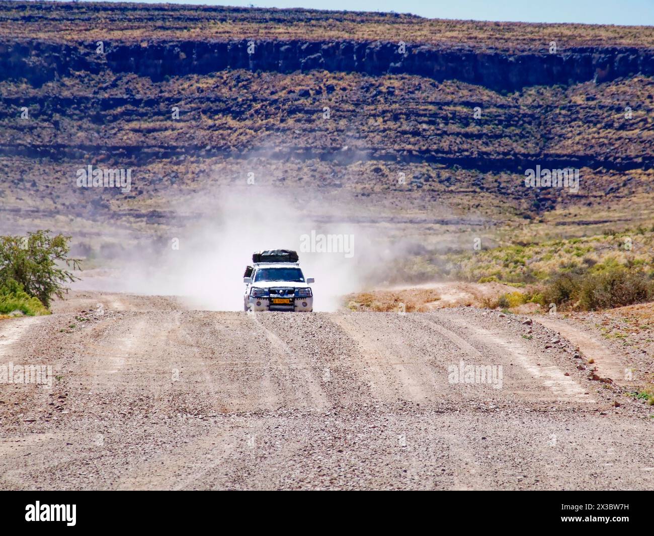 Un véhicule à quatre roues motrices, emballé avec une tente de toit, sur la route de gravier C13 au pied des montagnes Hunsberg dans le sud de la Namibie. Karas Banque D'Images