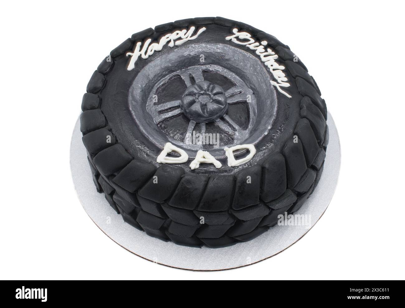 Joyeux anniversaire papa gâteau au chocolat designer moderne sous la forme d'un pneu en caoutchouc de voiture noir avec fondant foncé comme motif de bande de roulement hors route. Isolé sur Banque D'Images